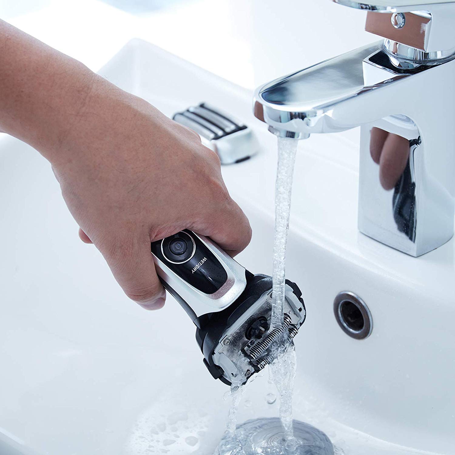 man washing panasonic arc 5 electric shaver in sink
